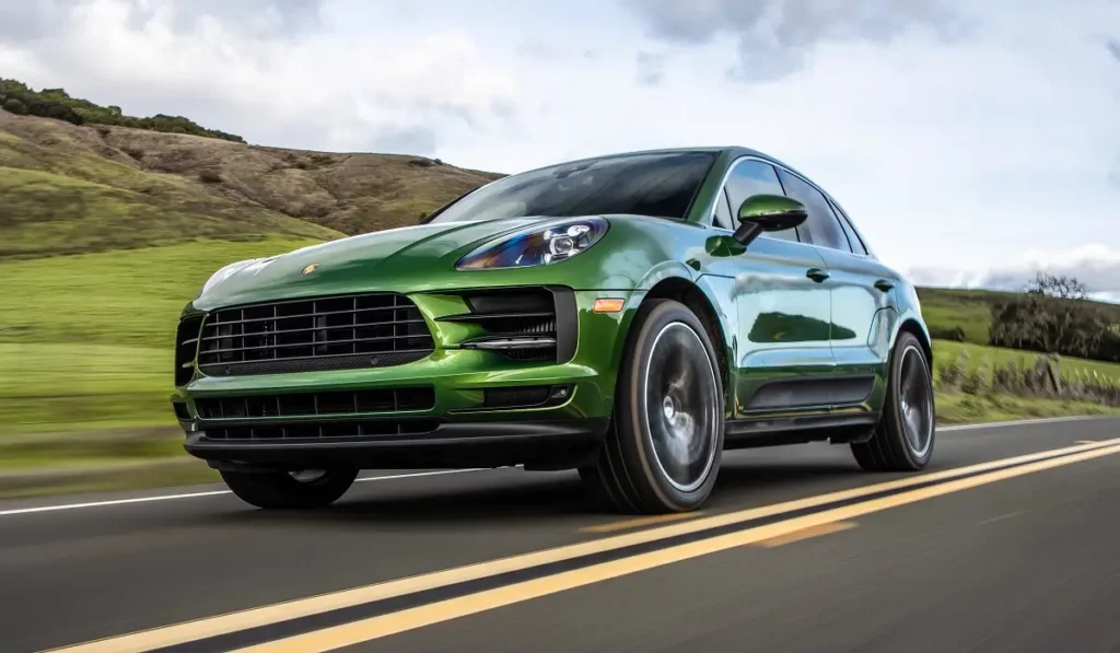 moving green Porsche Macan with mountain background