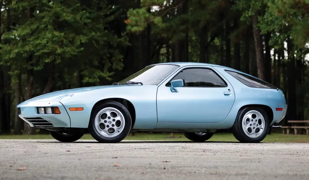 blue porsche 928 side view forest background